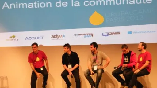 Cinq hommes assis sur sc&egrave;ne &agrave; une conf&eacute;rence DrupalCamp.